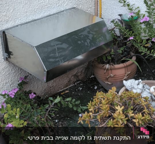 צינור גז צהוב מותקן על קיר חיצוני לצד חיפוי מתכת